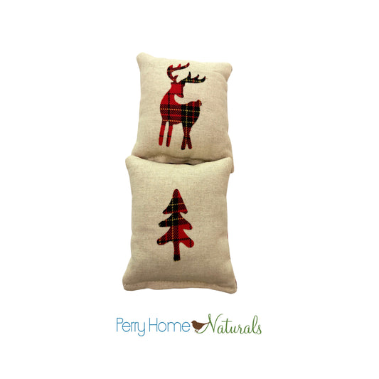 Two decorative pillows with reindeer and tree patterns on a white background, branded 'Perry Home Naturals'.